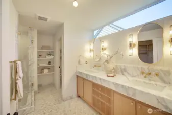Primary bathroom featuring Italian Carrara marble, Zellige tile from AnnSacks, custom handmade cabinetry,  fixtures from Waterworks, large walk-in shower, Rejuvenation light fixtures, and heated floors