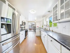 The galley kitchen with its white cabinet and stainless steel appliances is stylish and functional.