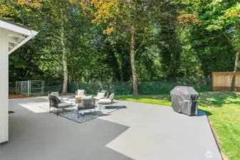 French doors off the great room open to a brand-new, oversized concrete patio — ideal for entertaining — and the fully fenced backyard backs to a forested greenbelt with a sprawling lawn.