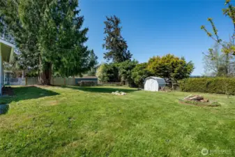 The property offers a spacious yard with a fire pit and a storage shed, giving ample outdoor space for relaxation and entertaining