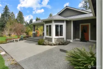 Private patio off rambler with covered entry and landscaped surroundings.