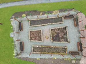 Top-down view of fenced garden with raised beds—ready for planting.”  Some crops are already planted for you. Come see to be surprised.