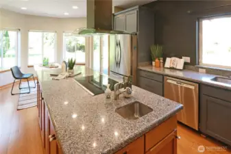 Open-concept kitchen featuring expansive counters, modern finishes, and excellent accessibility throughout. The prep sink in the island is a great feature and cooks love the easy clean glass top range with modern extractor fan.