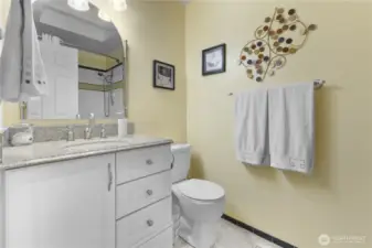 Full main bath with granite counters marble floors jetted tub with tile surround.