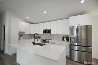 Beautiful kitchen boasts large island, stunning backsplash & SS appliances.