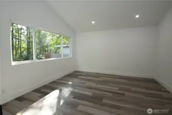 Bdrm #3 ~ Bright & cheerful primary suite with a large window framing the backyard and river.