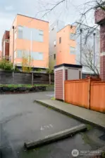 Parking space is steps from the front door of the unit. Yard behind the new cedar fence is solely for this unit, with a storage shed that is shared with a neighbor.