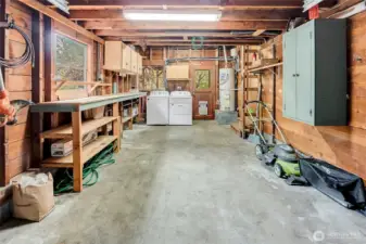 One car Garage with work bench, cabinets and laundry. ladder on the left leads to a large garage attic storage space.