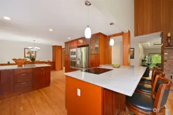 The kitchen, remodeled in 2018, is modern and stylish, boasting a breakfast bar, quartzite counters and backsplash, a Gasland Chef induction cooktop and a downdraft range hood.