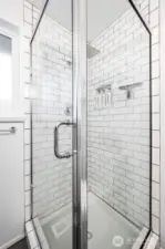 This primary suite bathroom keeps it simple yet sleek with dark tile floors, crisp white subway tile, and a glass shower. The single basin sink vanity adds a streamlined touch that makes every morning feel fresh.