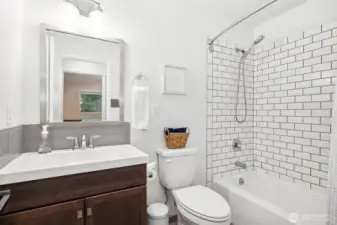 We’ve got subway tile, contrasting grout, and a showerhead that works both ways—what more do you need? The glass backsplash adds a pop of polish to the vanity, so this bathroom is both functional and fabulous.