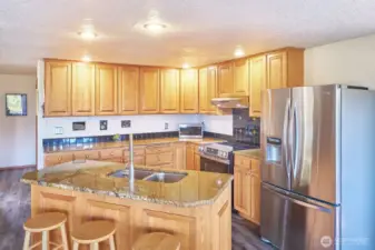 Oak cabinets, new stove and granite slab island with sink.