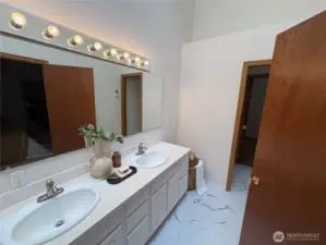This second view of the double vanity reveals the private toilet nook beyond—and a convenient connection to the second bedroom, perfect for guests or flexible living.