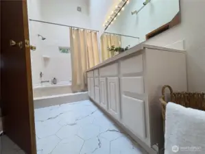 Newly installed marble tile flooring brings a bright, clean finish to the space—elevating the bathroom with timeless style and easy-care elegance. There’s even room for a laundry basket or additional storage.