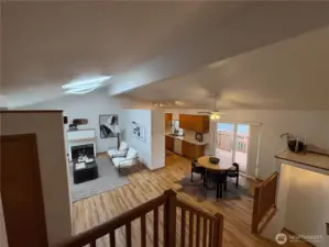 As you come down the stairs, take in the expansive vaulted ceilings that connect the entry, living, dining, and kitchen areas—creating a sense of light, space, and flow throughout the home.