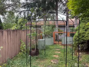 Follow the path as it winds deeper around the home, revealing more of the thoughtfully designed outdoor space—perfect for quiet moments, exploration, and seasonal gardening.