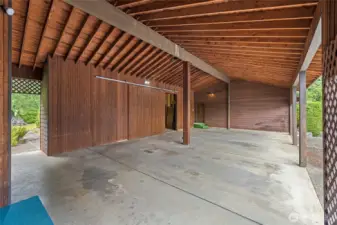 Huge carport with door that leads into the shop