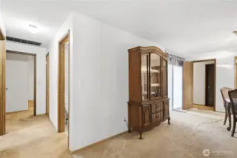 Looking down the hallway between the living room and the formal dining room towards the 3 bedrooms and the full bath room