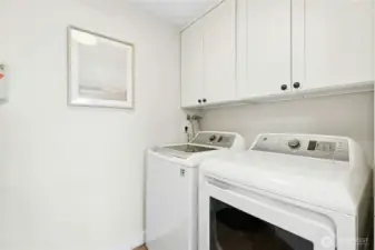 Dedicated laundry room with built-in storage shelves. Washer and dryer included.