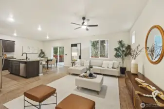 Living room opens to the kitchen and the  windows face the wooded area behind the home