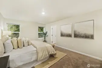 Primary bedroom looks out over the backyard and wooded area behind