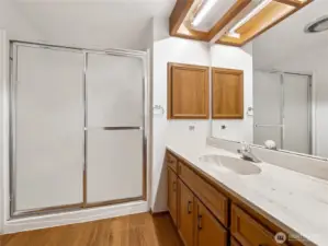 The primary bath has a large walk in shower and large vanity area with plenty of storage.