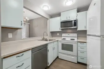 The freshly painted kitchen is open to the dining space and features updated lighting, new floors, a new microwave and dishwasher.