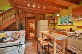 View as you enter the main living area of the cottage. Entry is to your back. Bathroom is straight ahead. Propane oven/range. Window over the sink looks out upon the forest.