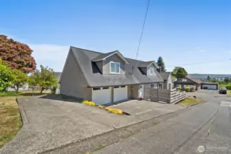 View of the property from Division St. RV parking to the left + attached garage.
