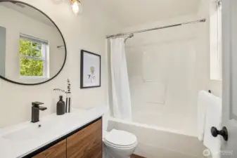 One of two full bathrooms on the upper level. This one is part of the primary suite.Updated with modern finishes.