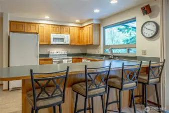 The eating bar seats four. The island is full of cupboards and drawers, adding lots of kitchen storage.