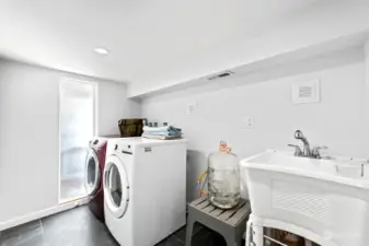 The utility room features a large wash basin and the washer and dryer stay with the new owners.