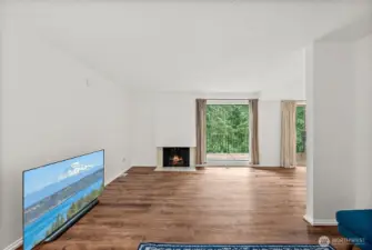 Spacious living room featuring recently updated LVP flooring and a cozy fireplace—perfect for relaxing or entertaining