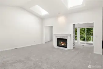 Built in bookshelves on the sides of the fireplace lead to a sunny space.