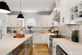 Beautiful kitchen with Bertazonni appliances and beautiful surfaces. Note integrated dishwasher, two ovens and wine/beverage fridge.