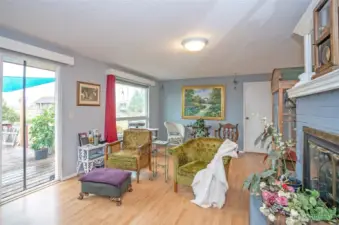 Another view of the living room and wood burning fireplace. Floor is newer laminate.