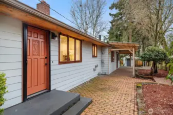 Covered entry to the formal living room, with brick walkway.