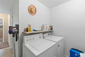 Laundry room in daylight basement.  Built in shelving opposite the washer and dryer.