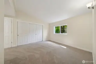 Primary bedroom with lots of closet space & vaulted ceilings.