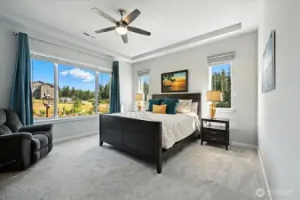 Bright and airy primary bedroom with picturesque windows overlooking the back yard and garden