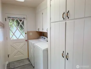 The laundry room is full of cabinets and has an exterior door