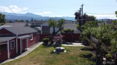 Large lush backyard await you with a garage, and two storage buildings (one is quite large)