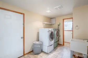 Laundry room paired with a toilet and sink makes pit stops quick and easy before heading out to the garage.