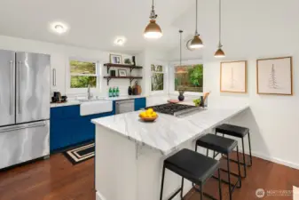 A stunning remodel of this kitchen with Carrera marble counters, Wolf Gas Range, farmhouse sink, designer lighting, counter seating and even a a breakfast nook overlooking the serene-quite backyard.