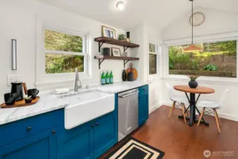A stunning remodel of this kitchen with Carrera marble counters, Wolf Gas Range, farmhouse sink, designer lighting, counter seating and even a a breakfast nook overlooking the serene-quite backyard.