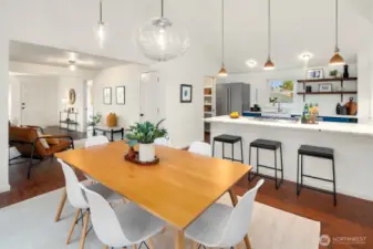 This bright living room was a thoughtful remodel with cathedral ceilings, surrounded by double paned windows, and designer lighting. French doors expand the interior living space to the deck and expansive back yard.