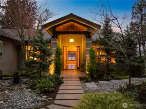 Inviting entry with custom fir door, covered front porch, and thoughtfully designed landscape approach.