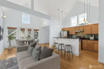 Open-concept living, dining, and kitchen area with soaring vaulted ceilings and abundant natural light.