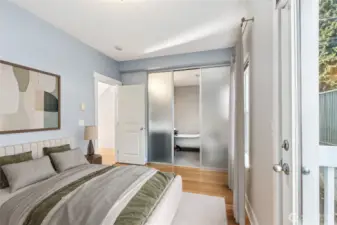 Private second bedroom suite with clawfoot soaking tub, walk-in closet, and access to a small outdoor deck.