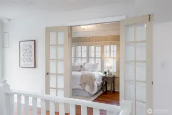 French doors open into a darling bedroom, full of charm